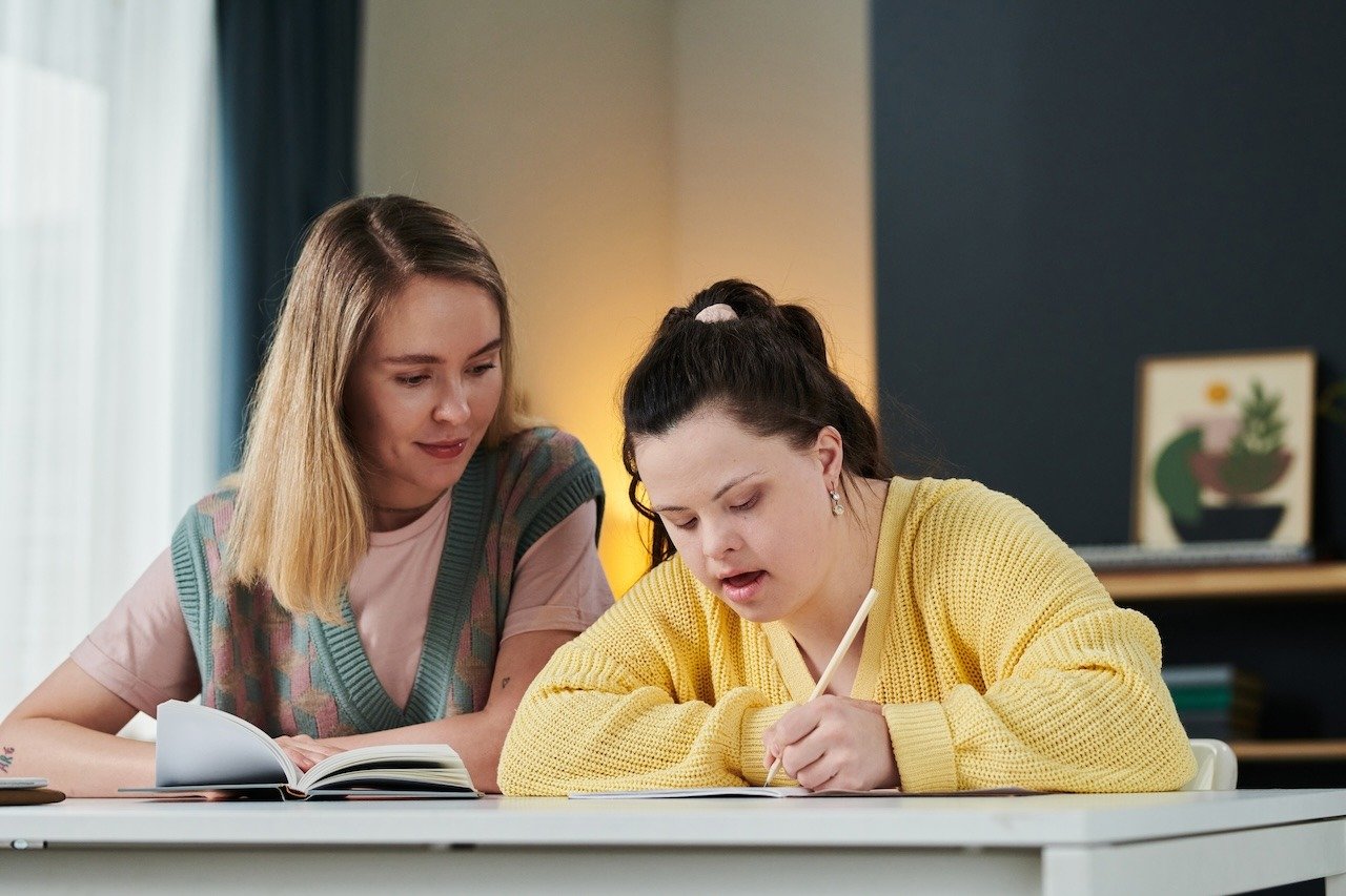 young-woman-teaching-girl-with-disability